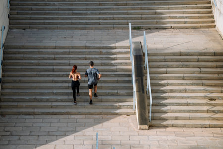 Sportive couple during workout stair running outside. Fitness active lifestyle athletic people...