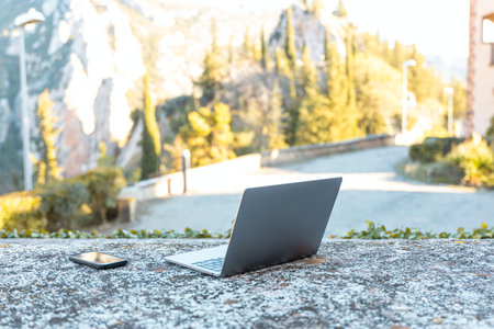 Outdoor stone table with a reusable bottle and a gray laptop on it. travel and vacation conceptの写真素材
