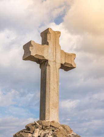 Low angle view of a stone cross at sunsetの写真素材