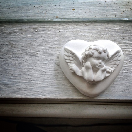 clay angel hanging on white woodの素材