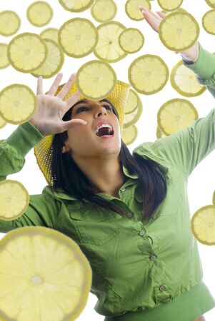 pretty girl with colored dress and pieces of fruit all around herの写真素材
