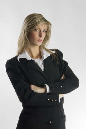 blond and attractive young woman in formal black suit making facesの写真素材