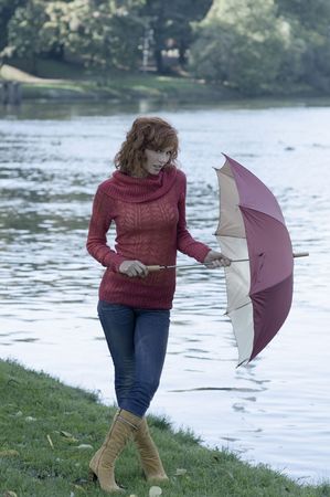 woman near a river with umbrella after a fall rainの写真素材