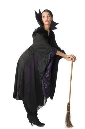nice witch in black taking pose using a broom as a walking stickの写真素材