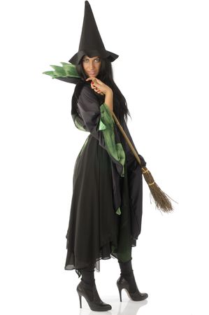 beautiful witch with hat and broom in black and green dressの写真素材