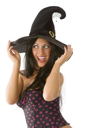 beautiful  brunette with blue eyes and witch hat on making faceの写真素材