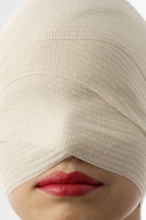 close up of woman with bandage around face and red lipsの写真素材