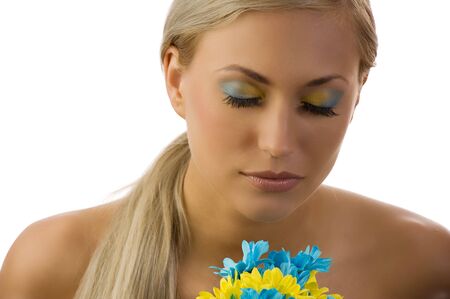 cute young woman with closed eyes and colored make up and daisyの写真素材
