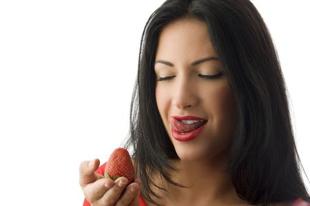 beautiful and sensual brunette looking a strawberry on her hand の写真素材