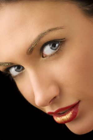 beauty portrait of cute brunette with golden make up on eyes looking in cameraの写真素材
