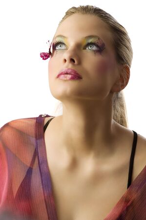 Beautiful blond woman with creative makeup with butterfly on her face looking upの写真素材