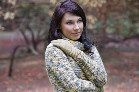 pretty young brunette in a forest in winter with a nice and sweet colored pulloverの写真素材