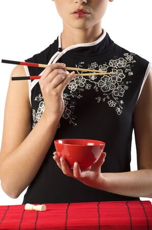 close up of a beauty asian woman in oriental dress with a red cup and chopstickの写真素材