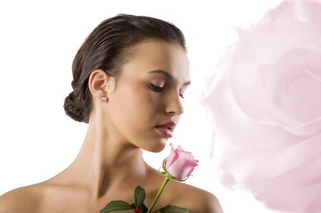 close up portrait of a cute girl brunette looking a pink rose の写真素材