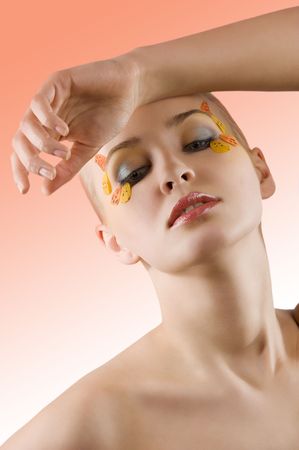 very nice and young blond model posing with a creative colored make up on whiteの写真素材