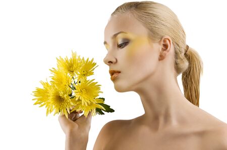 profile shot of cute blond girl looking at some yellow flowers. wellness conceptの写真素材