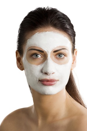 young woman getting beauty skin treatment with a cream mask on her faceの写真素材
