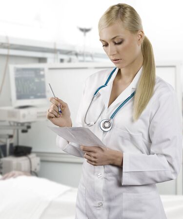 blond medical doctor woman with stethoscope Isolated over white background writingの写真素材