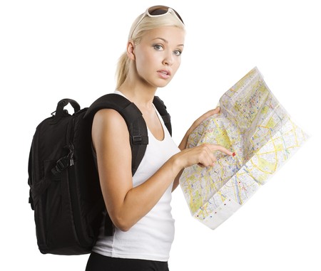 young pretty student girl in vacation looking for place on a map with rucksackの写真素材