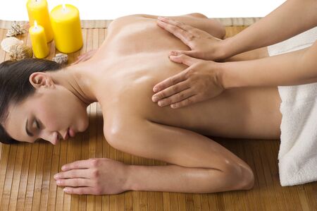 cute woman laying down on wood carpet with candle near getting an oil massageの写真素材