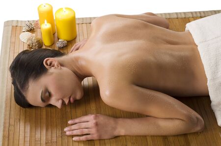 beautiful brunette relaxing herself in a spa with drops of water on her naked shoulderの写真素材