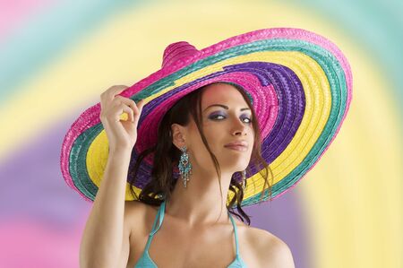 summer portrait of a cute girl wearing a bikini colored scarf and a big colorful hat like a sombreroの写真素材