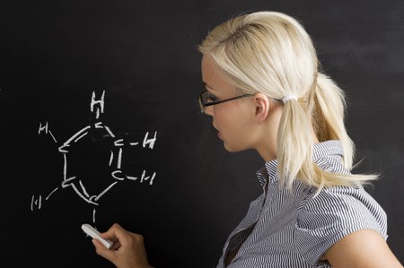pretty young college student writing on the chalkboard/blackboard during a math classの写真素材