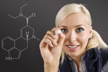 pretty young college student writing on the chalkboard/blackboard during a math classの写真素材
