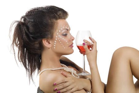 beautiful woman with creative make up and hair style looking at a glass of red wineの写真素材