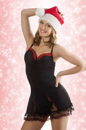 attractive smiling blond woman wearing a red and black baby doll and a christmas hat looking in cameraの写真素材