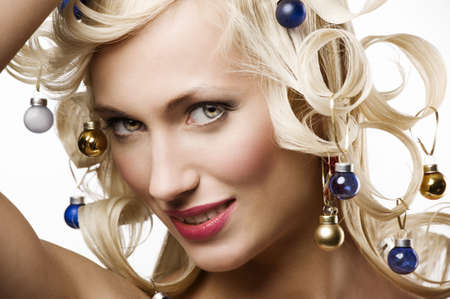 fashion shot of a blond girl with curly hair stylish like a christmas tree with little noel decorationの写真素材