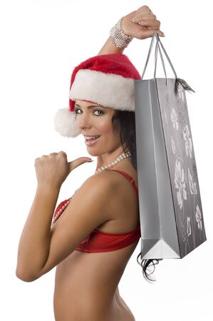 young and pretty girl wearing a red bra and a christmas hat and showing a shopping bag and smilingの写真素材