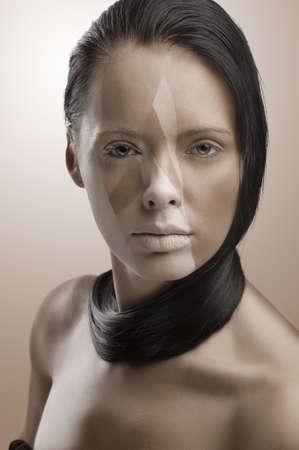 close up beauty portrait of young woman with her face painted in brown color as artistic make upの写真素材