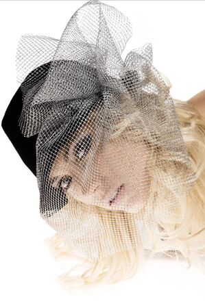 creative portrait of blond beautiful girl with hair style black hat and a silver net over her face の写真素材