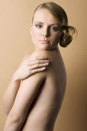 portrait of a naked woman on sepia background color with hair style looking in cameraの写真素材