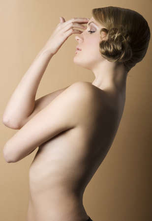 graceful blond woman with naked shoulder and old fashion hair style on sepia background の写真素材