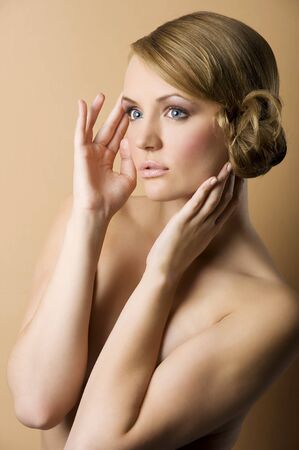 graceful blond woman with naked shoulder and old fashion hair style looking one one sideの写真素材