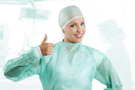 smiling a positive young beauty nurse in green operation dress with surgery capの写真素材