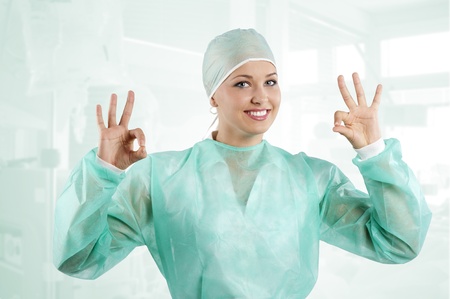 positive smiling woman with nurse dress acting and doing sign with handの写真素材