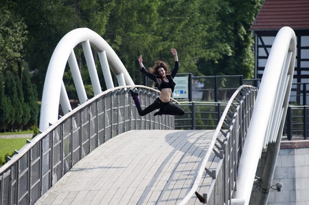 young modern dancer jumping outdoor on a white bridgeの写真素材