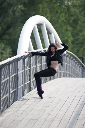 casual sport dressed woman doing fitness exercise outside on a bridge の写真素材