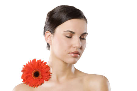 fresh portrait of a young brunette woman wiith color flower near the her faceの写真素材