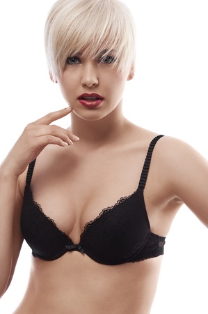 young and sexy blond woman wearing a black bra with hair style against white background の写真素材