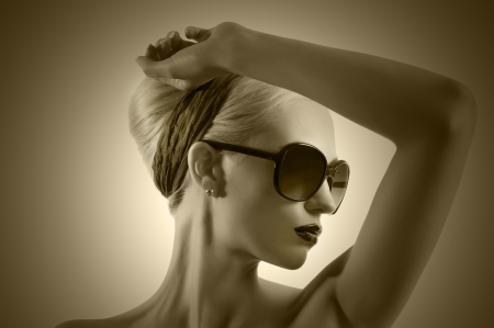 fashion portrait of young blond woman with hair style black lips and wearing sunglasses posing against white backgroundの写真素材