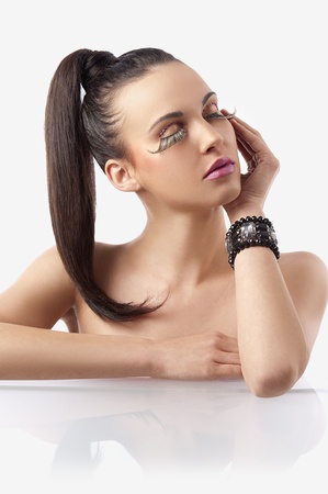portrait of pretty and sensual brunette with hair pony  tail and creative make up with long eyelashes posingの写真素材