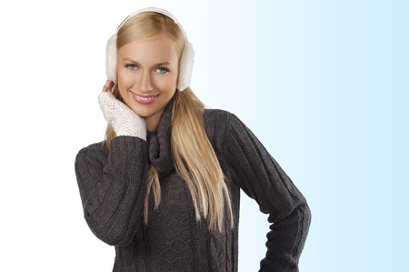 young pretty woman wearing white earmuffs and gray wool sweater be ready to go out in a cold winter day against white background
の写真素材