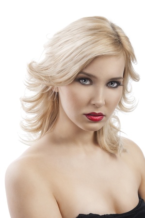 beauty portrait close up of very cute blond girl with hair style flying in wind, she looks in to the lens and is portrayed in half-lenghtの写真素材