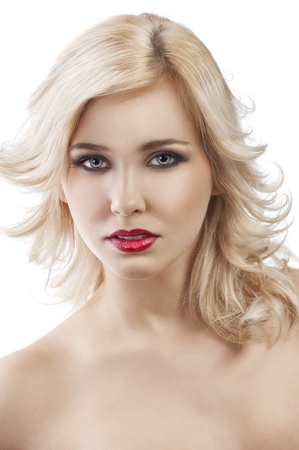 beauty portrait close up of very cute blond girl with hair style flying in wind, she is in front of the camera , looks in to the lens and smilesの写真素材