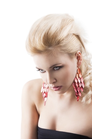 sensual portrait of very attractive blond woman with creative hair style and big fashion red earring with black top, she is turned of three quarters with a bent head and looks in front of her with an actractive expresisonの写真素材
