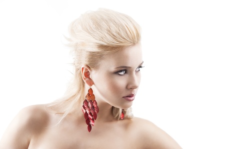 sensual portrait of very attractive blond woman with creative hair style and big fashion red earring with black top. she is in front of camera with head tunerd at left and looks in front of her.の写真素材